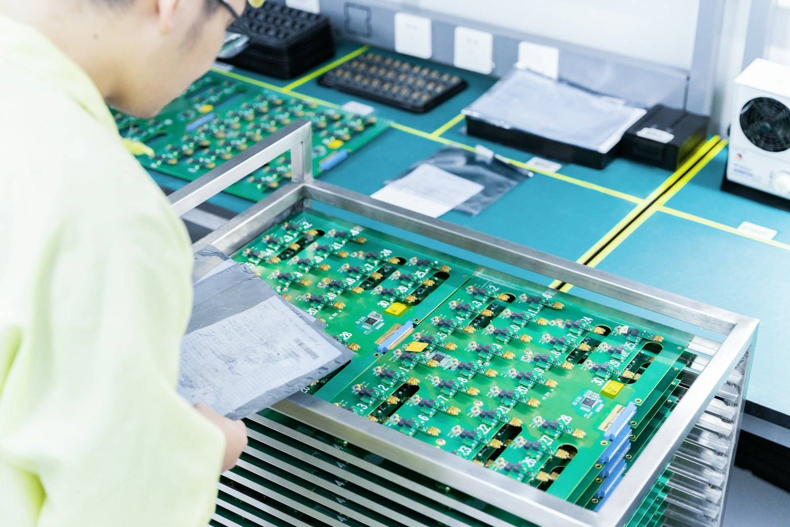 An operator next to a rack of assembled boards
