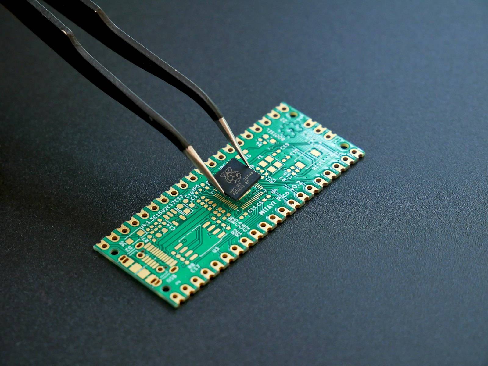 Tweezers placing a chip on a circuit board